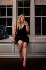 fit woman drinking wine in dark room