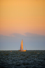 gold and blue sunset with sailboat