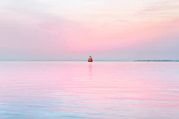 Pink sunset on chesapeake bay with red lighthouse in maryland us