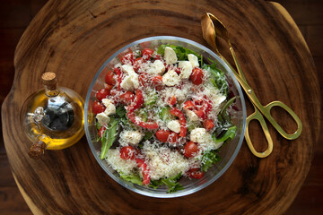 fresh salad on wood background with gold colored servers