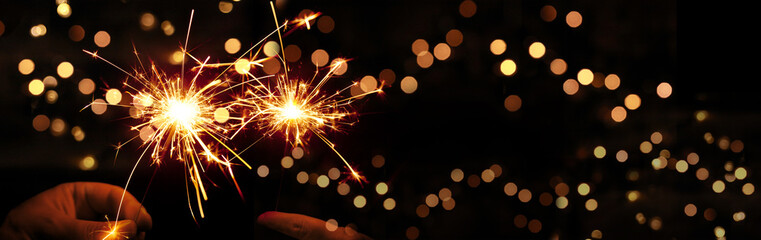 Happy New Year background with glowing sparklers.