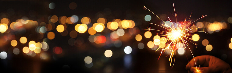 Happy New Year background with glowing sparklers.