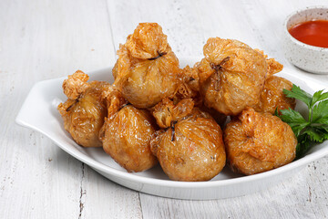 Ekado or ekkado is processed fish or shrimp meat wrapped in dumpling skin and shaped like a bag filling with cheese whose upper part is tied with chives.