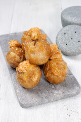 Ekado or ekkado is processed fish or shrimp meat wrapped in dumpling skin and shaped like a bag filling with cheese whose upper part is tied with chives.