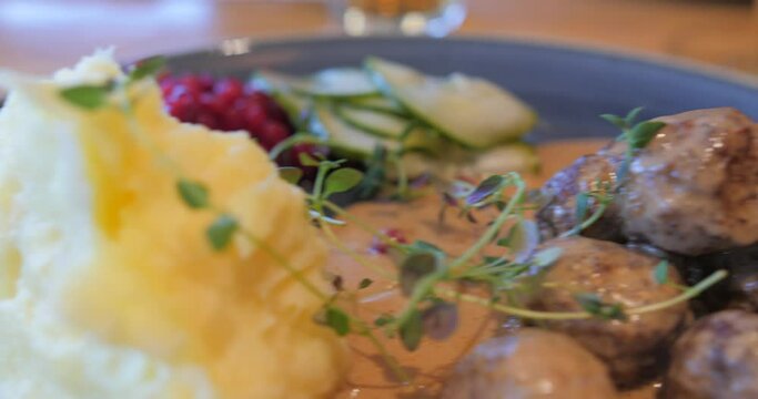 Slow pan of Swedish meatballs and potato puree called K&ouml;ttbullar