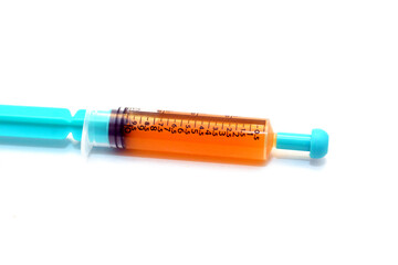 A brown medical syrup 10 ml inside an oral plastic syringe isolated on white background ready for oral administration to an infant, selective focus of a child medication drug therapy for a sick infant - obrazy, fototapety, plakaty
