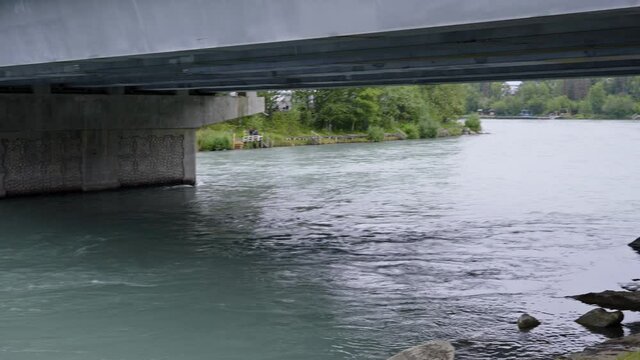 Stream of water green river under a concrete bridge in alaska