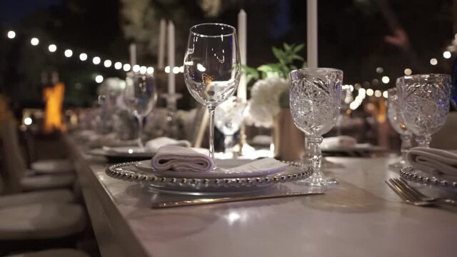 An elegant table at night, set up for a banquet.