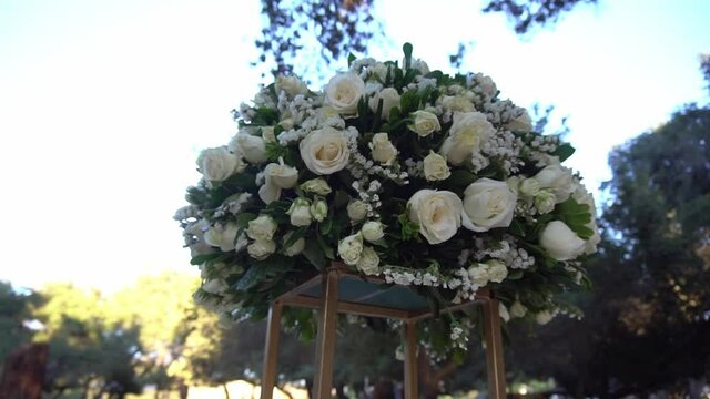 A bouquet of white roses on a golden vase.