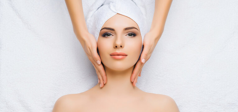 Young and healthy woman gets massage treatments for face, skin and neck in the spa salon. Health, wellness and rejuvenation concept.