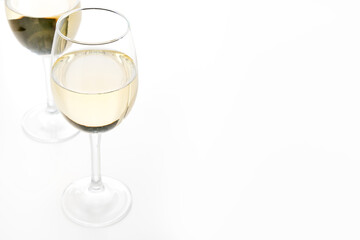 Two glasses of white wine, close up. Wine glasses on a white background with copy space.