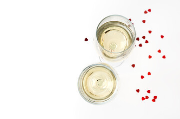 Two glasses of wine and decor of hearts. Wine glasses over a white backdrop with copy space