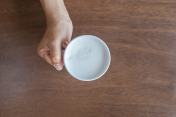holding a glass of ready-to-drink milk