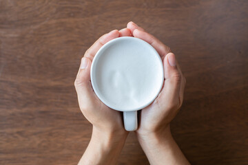 holding a glass of ready-to-drink milk