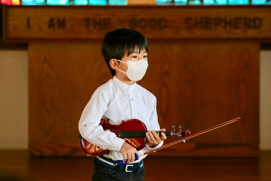 Asian Boy Is Playing Violin On Stage.