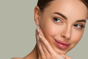 Beautiful skin face woman natural make up healthy skin touching her face. Color background. Green