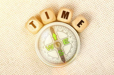 On the table is a compass and cubes with the inscription - TIME