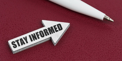 On a red background lies a white pen and a white arrow with the inscription - STAY INFORMED