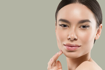 Asia woman beauty face body portrait touching her face healthy skin. Color background. Green