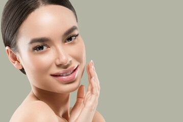 Obraz na płótnie Canvas Asia woman beauty face body portrait touching her face healthy skin. Color background. Green