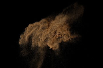 Naklejka na ściany i meble Sandy explosion isolated on black background. Abstract sand cloud.