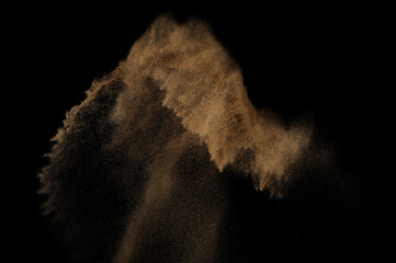 Sandy explosion isolated on black background. Abstract sand cloud.