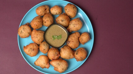Delicious Indian snacks Punugulu served in a plate with Tomato and green Chutney