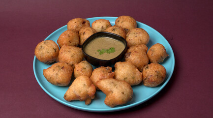 Delicious Indian snacks Punugulu served in a plate with Tomato and green Chutney