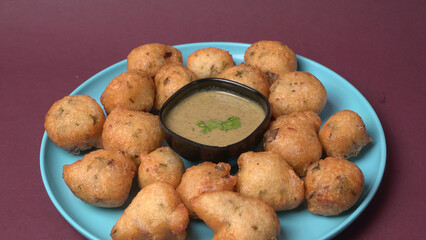 Delicious Indian snacks Punugulu served in a plate with Tomato and green Chutney