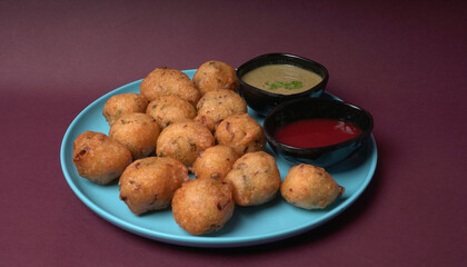 Delicious Indian snacks Punugulu served in a plate with Tomato and green Chutney