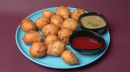 Delicious Indian snacks Punugulu served in a plate with Tomato and green Chutney