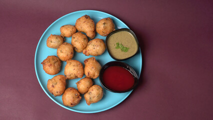 Delicious Indian snacks Punugulu served in a plate with Tomato and green Chutney