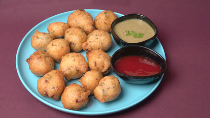 Delicious Indian snacks Punugulu served in a plate with Tomato and green Chutney