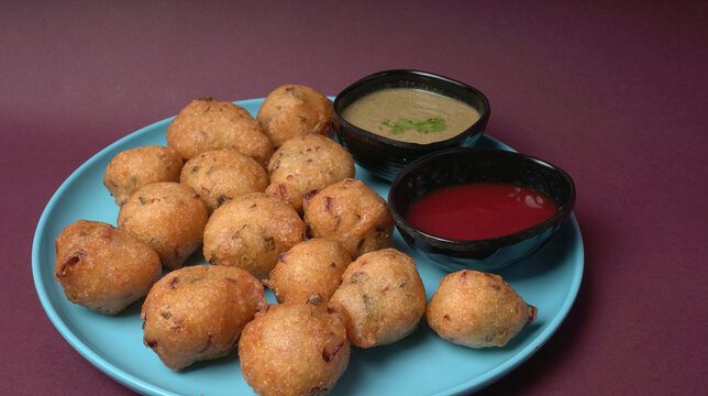 Delicious Indian snacks Punugulu served in a plate with Tomato and green Chutney