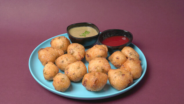 Delicious Indian snacks Punugulu served in a plate with Tomato and green Chutney