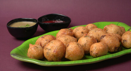 Delicious Indian snacks Punugulu served in a plate with Tomato and green Chutney