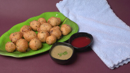 Delicious Indian snacks Punugulu served in a plate with Tomato and green Chutney