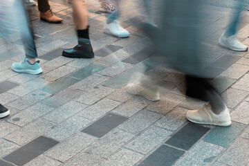 Motion blur of walking people in the street. Low angle view of crowded street.