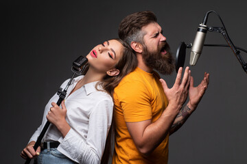 Singing man in a recording studio. Expressive couple with microphone. Karaoke duet signers, musical vocalist.