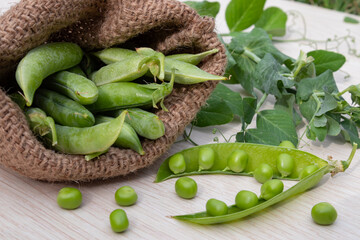 Healthy fresh green peas and pods on rustic wooden background