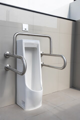 Public disabled toilet in a large building. Modern restroom for disabled people. Inside disable toilet or elderly people. Handrail for disabled and elderly people in the bathroom.