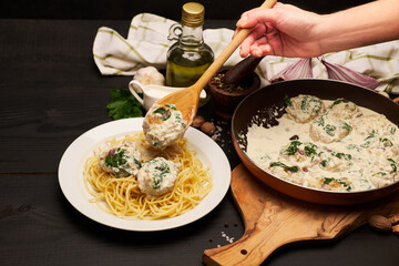Portion of delicious meatballs with spinach in a creamy sauce