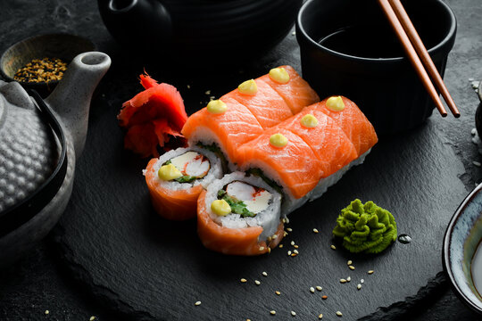 Sushi roll (Philadelphia) with salmon, avocado, cream cheese on a black background. Sushi menu. Japanese food.
