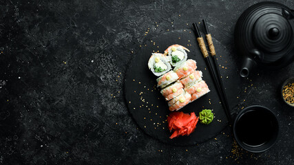 Delicious sushi rolls with shrimp and philadelphia cheese. Traditional Japanese food. On a black stone plate. © Yaruniv-Studio