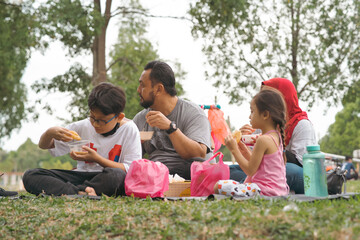 Bangi, Malaysia - Oct 16, 2021 Family picnic and eating at the park.