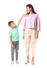 Fototapeta premium Little boy with his older sister on white background