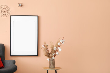 Interior of stylish room with dark armchair and blank poster