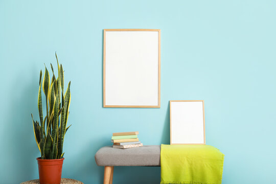 Stylish bench near color wall with blank poster