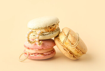 Macaroons and stylish jewelry on color background