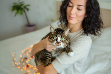 Young beautiful woman with cute cat resting at home. Domestic pet concept.
